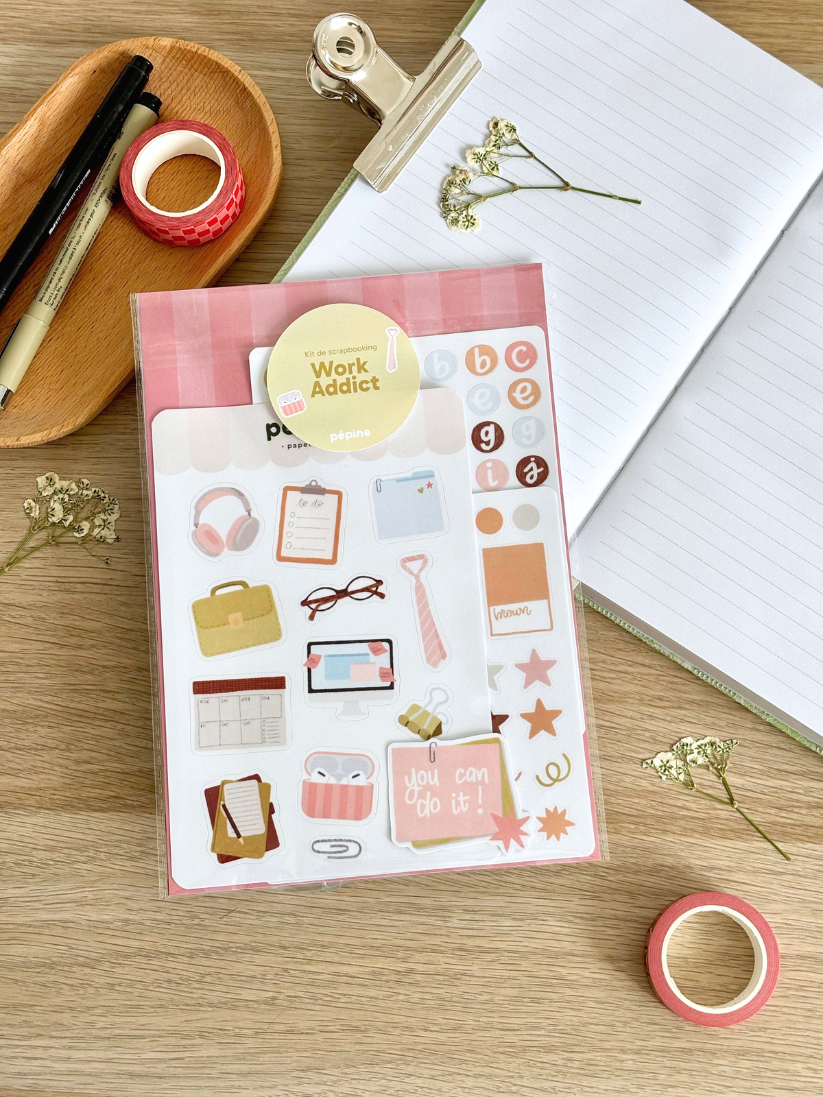 Contenu du kit Work Addict présenté à plat : planches, fonds papier et sticker à l'unité