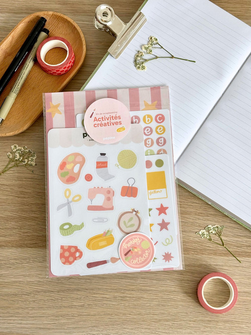 Contenu du kit Activités créatives présenté à plat : planches, fonds papier et sticker à l'unité