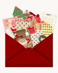 Box de Noël Pépine : enveloppe rouge débordant de stickers, planches et fonds de scrapbooking de Noël