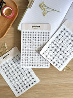Les trois planches Lettres & chiffres noir et blanc photographiées sur un bureau en bois