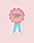 Sticker Birthday Girl : rosette d'anniversaire rose et bleue, finition brillante